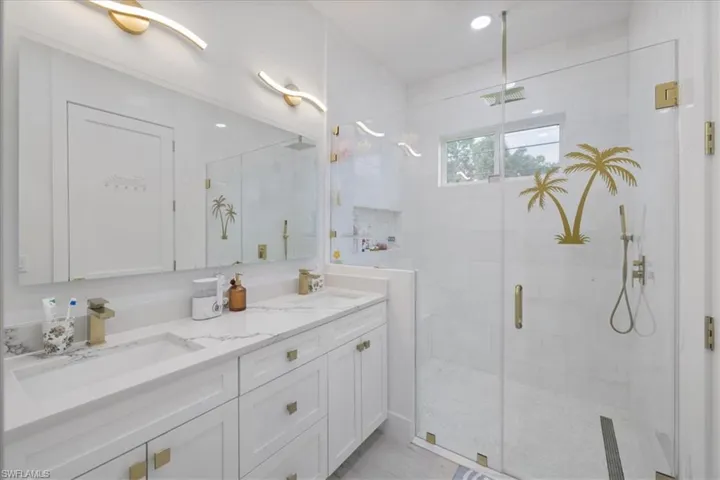 Bathroom featuring a stall shower and double vanity