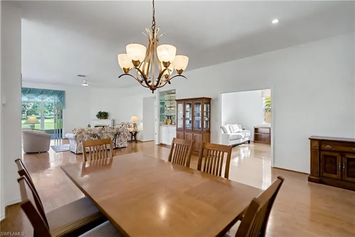 Dining room with light wood-style floors and a chandelier