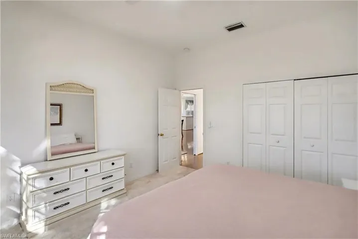 Bedroom featuring light carpet and a closet