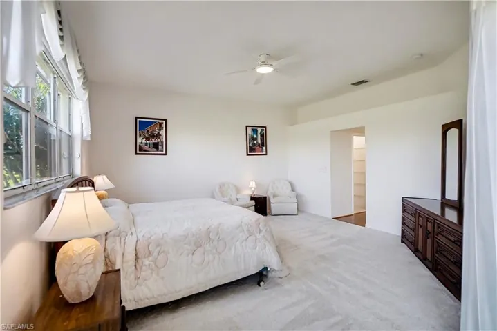 Carpeted bedroom featuring a ceiling fan