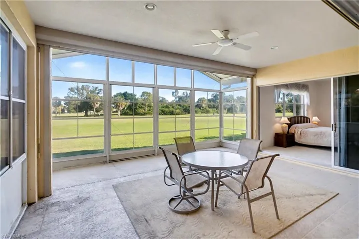 Sunroom with ceiling fan and view of golf course