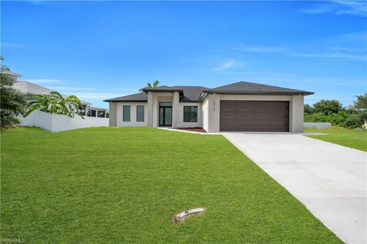 Contemporary exterior featuring a neutral stucco finish, dark asphalt shingle roof, and a two-car garage with a brown sectional door