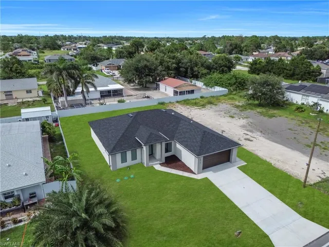 Contemporary single-story residence featuring a dark shingle roof and a light-colored exterior