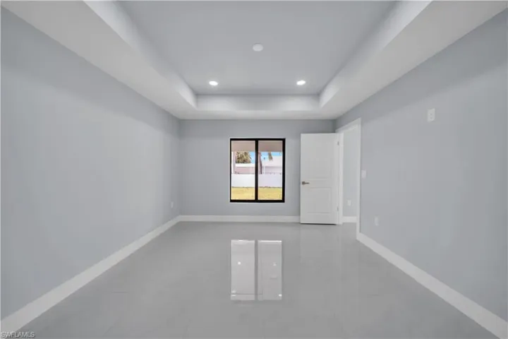 Spacious room featuring light gray walls and large format gray tile flooring