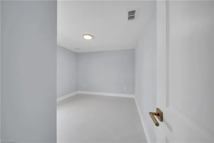 Bright interior space featuring light blue walls and a neutral-toned tile floor