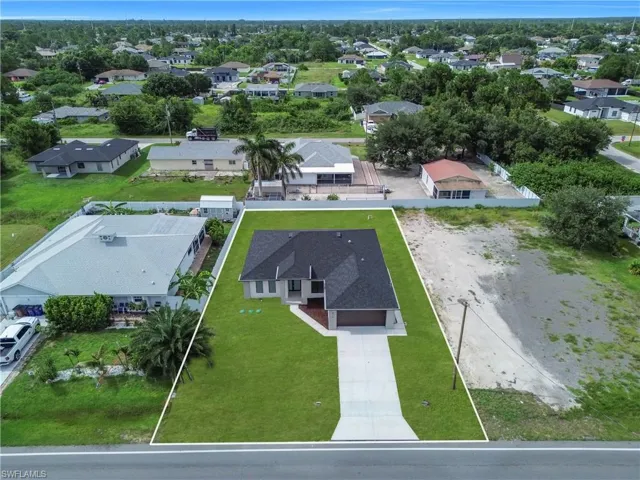 Newly constructed residence featuring a dark shingle roof and a light-colored stucco exterior