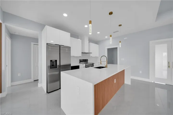Modern kitchen featuring a large island with a quartz countertop and wood-slat detailing