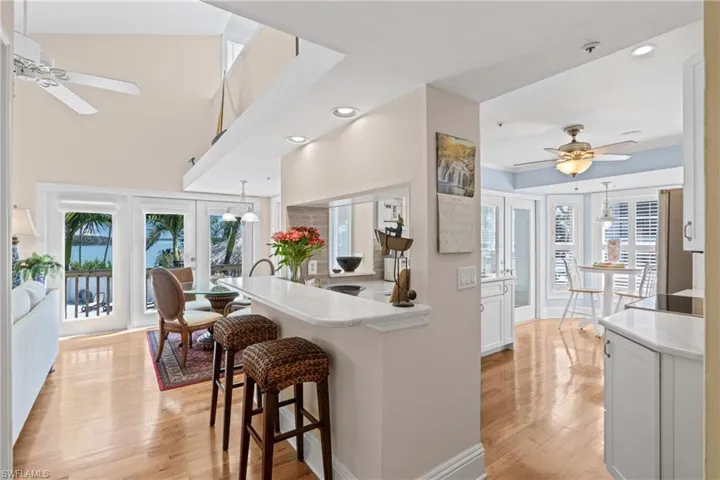 Kitchen featuring a ceiling fan, a breakfast bar area, pendant lighting, healthy amount of natural light, and recessed lighting