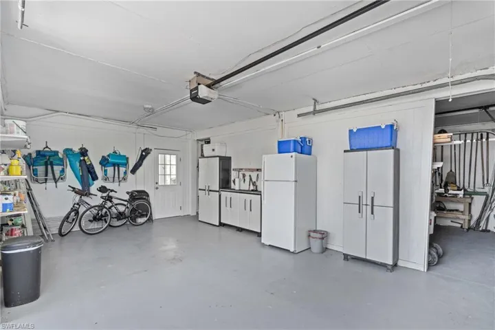Garage with freestanding refrigerator and a garage door opener