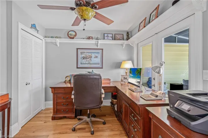 Office space with light wood-style floors and ceiling fan