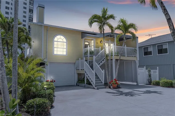 View of front facade featuring concrete driveway, a garage, stairs, and a deck