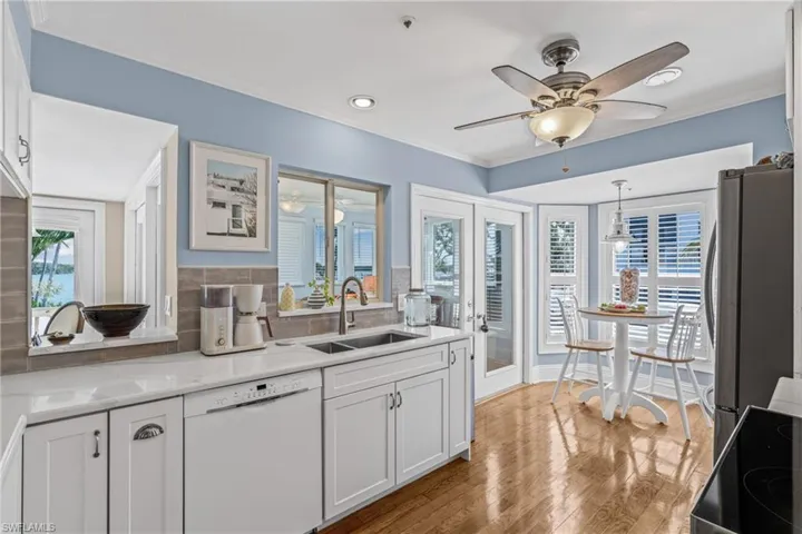 Kitchen with white cabinetry, white dishwasher, black range with electric cooktop, tasteful backsplash, and crown molding