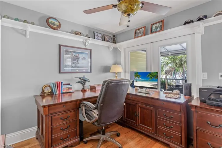 Home office with light wood finished floors and ceiling fan