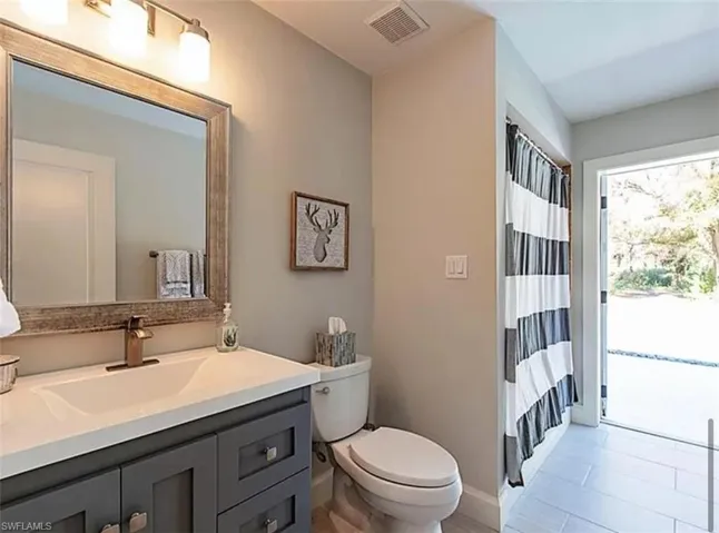 Bathroom with a shower with curtain and vanity