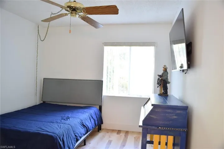 Bright room featuring wood-finish flooring and a ceiling fan