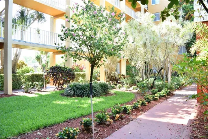 Lush, manicured landscaping with diverse plantings, mature trees, and a well-maintained lawn