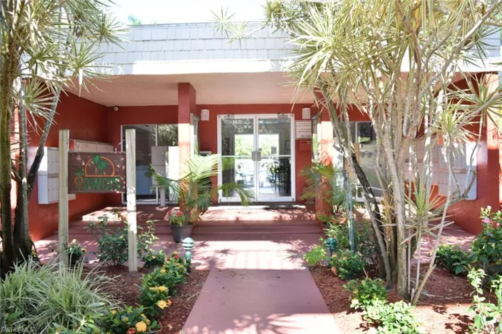 Entryway featuring a red exterior, white trim, and glass doors
