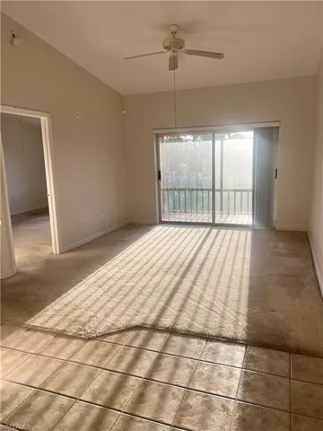 Carpeted living room with lofted ceiling and a ceiling fan