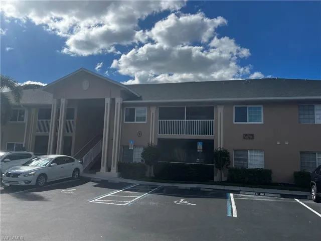 View of building exterior featuring uncovered parking