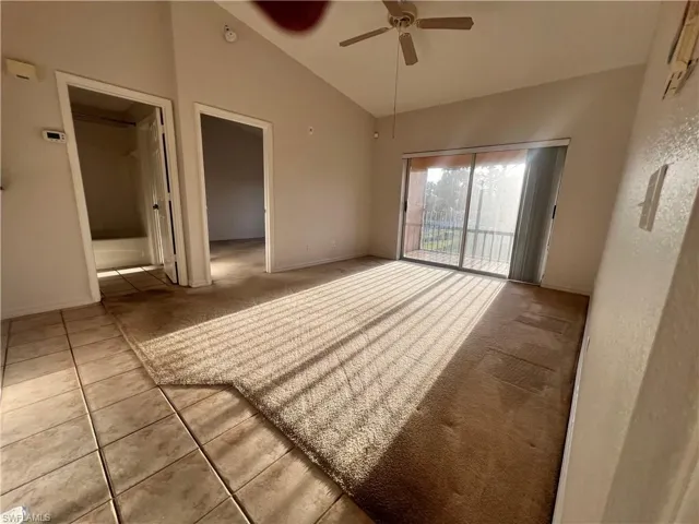 Carpeted living room with lofted ceiling and a ceiling fan