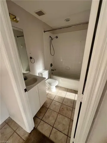 Bathroom featuring vanity, light tile patterned flooring, and bathtub / shower combination