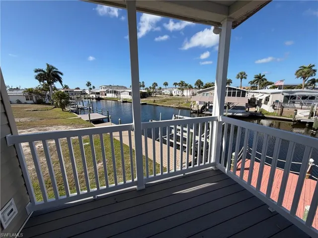 Deck with a residential view, a water view, a dock, and a yard