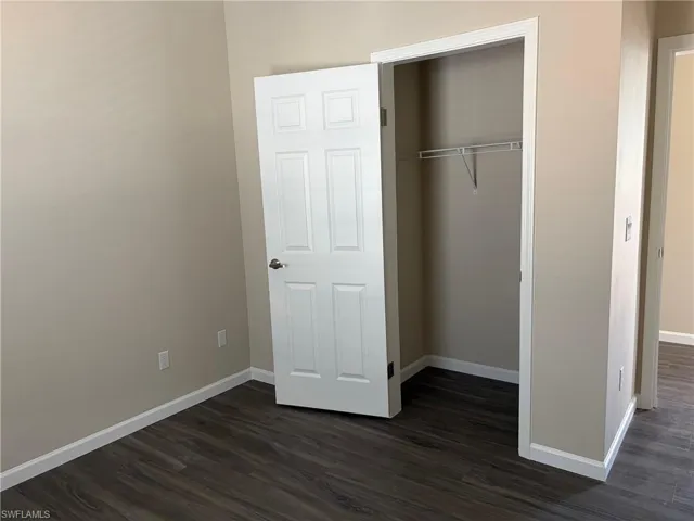 bedroom closet featuring dark wood finished floors and a closet