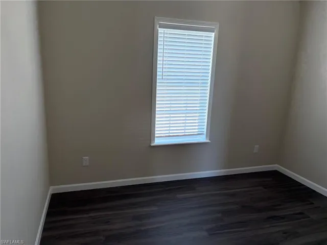 Empty room featuring dark wood-style flooring