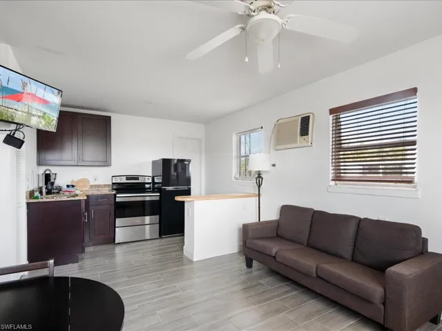 Living area with wood tiled floors and a ceiling fan