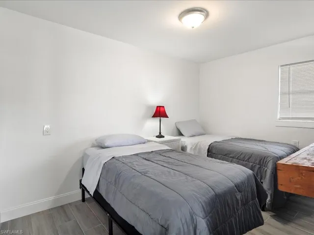 Bedroom with baseboards and wood finish floors