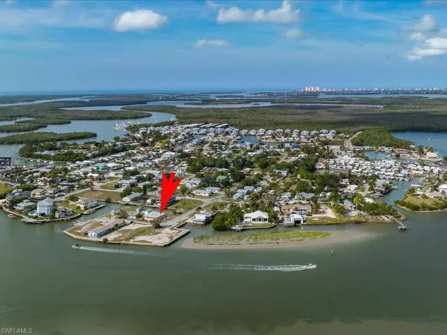 Aerial view of property and surrounding area featuring nearby suburban area and a nearby body of water