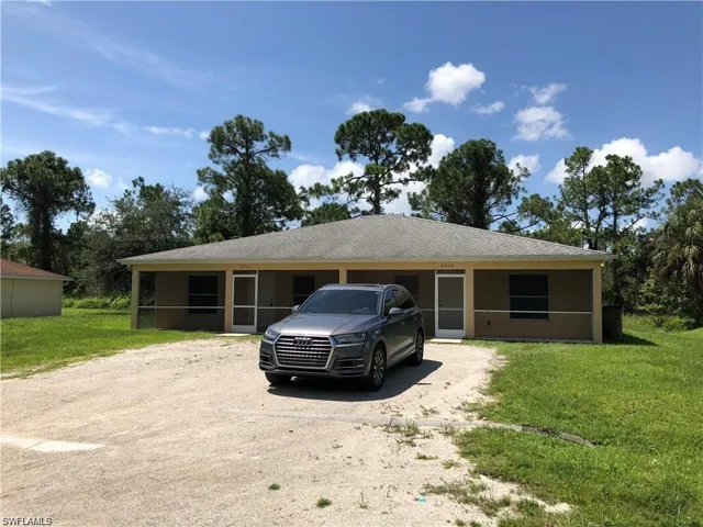 Ranch-style home featuring a sunroom, driveway, and a front lawn