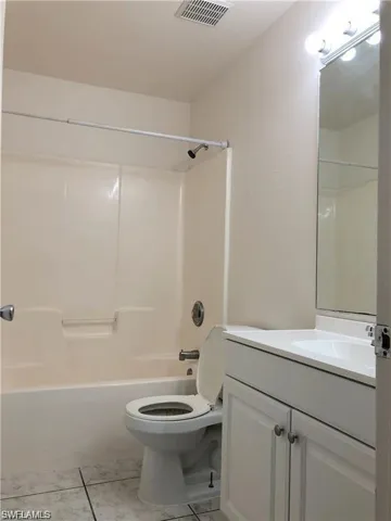 Bathroom featuring vanity, washtub / shower combination, and tile patterned floors