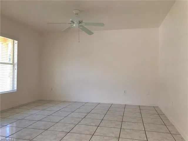 Spare room featuring plenty of natural light, light tile patterned floors, and a ceiling fan