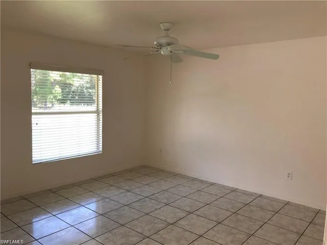 Unfurnished room with light tile patterned floors and ceiling fan