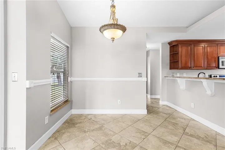 Unfurnished dining area with baseboards and light tile patterned floors