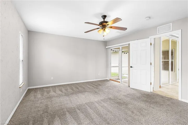 Empty room featuring light carpet and a ceiling fan