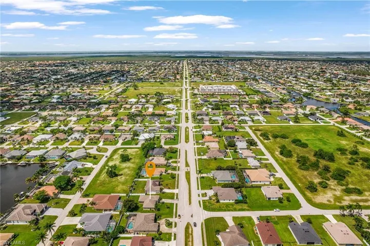 Aerial overview of property's location with a large body of water and nearby suburban area