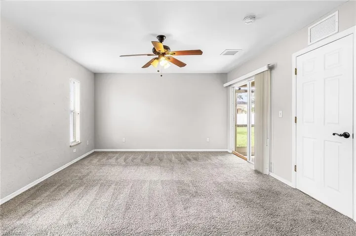 Unfurnished room with ceiling fan, carpet, and a textured wall