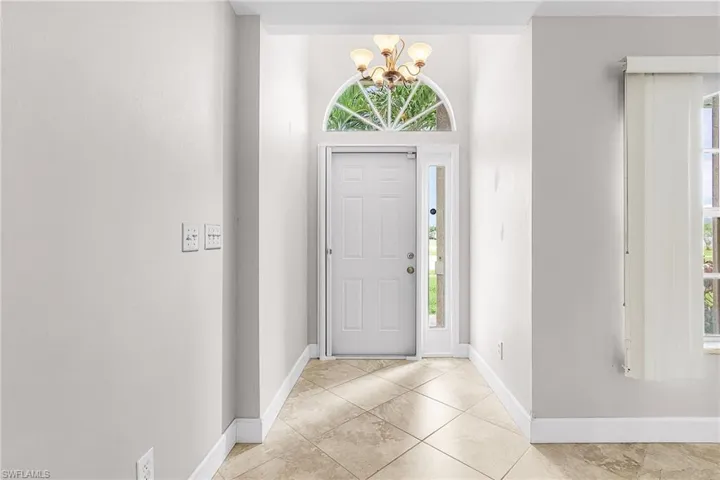 Foyer with a chandelier and light tile patterned flooring