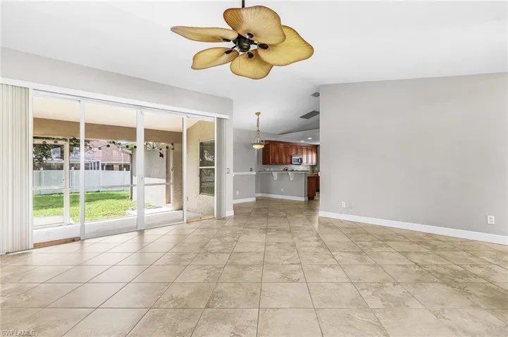Unfurnished living room with lofted ceiling, a ceiling fan, and light tile patterned floors