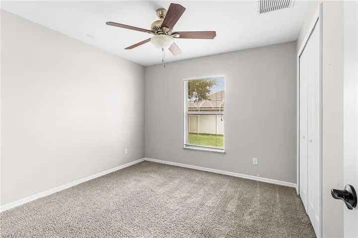 Unfurnished bedroom with carpet, a closet, and a ceiling fan