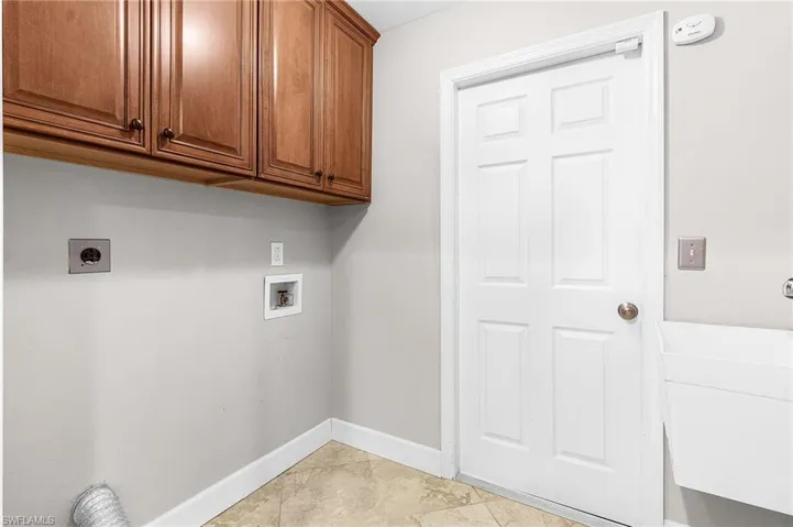 Laundry area featuring hookup for an electric dryer, washer hookup, and cabinet space