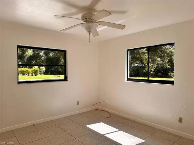 Tiled spare room with ceiling fan and a wealth of natural light