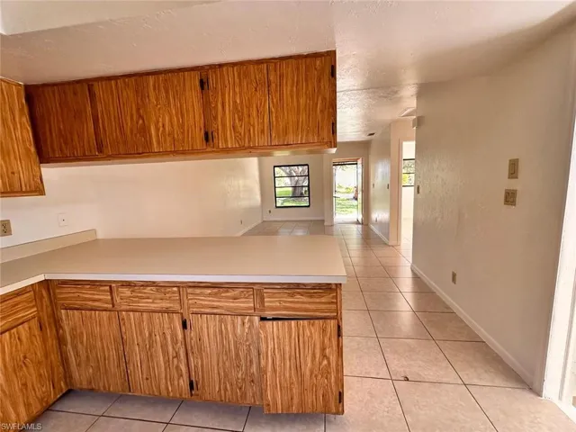 Kitchen with kitchen peninsula and light tile patterned floors