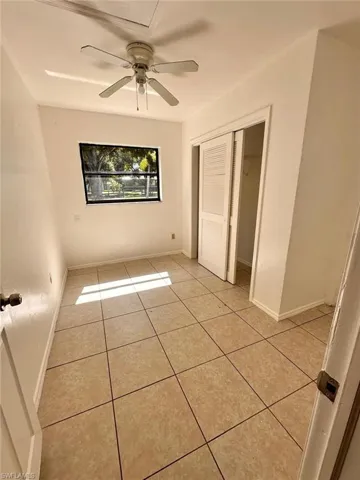 Unfurnished bedroom with light tile patterned floors, a closet, and ceiling fan