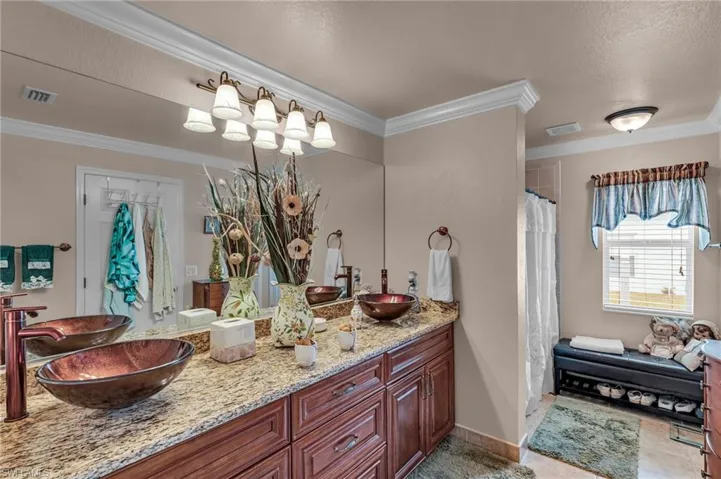 Bathroom featuring a shower with shower curtain, a textured ceiling, crown molding, and vanity