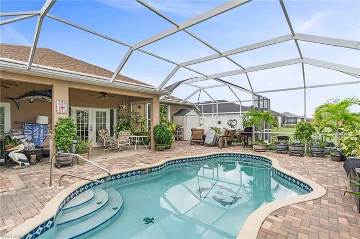 View of swimming pool featuring glass enclosure, a patio area, and ceiling fan