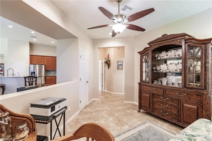 Living room with ceiling fan, light tile flooring, and sink