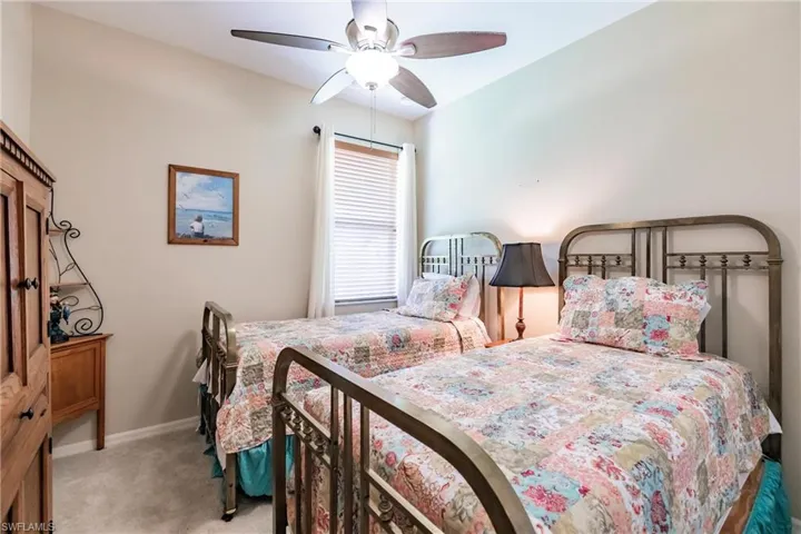 Carpeted bedroom featuring ceiling fan